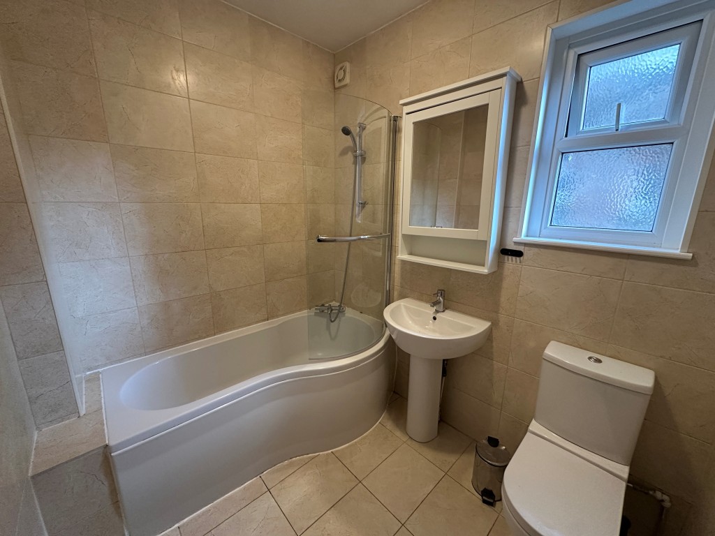 Lot: 57 - THREE-BEDROOM FIRST FLOOR FLAT WITH FRONT GARDEN & BALCONY - Bathroom with bath, shower, WC and basin